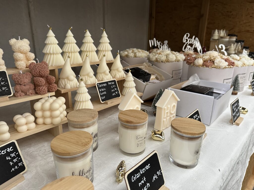 Weisse Kerzen in Form von Weihnachtsbäumen und rosa Kerzen in Form von Teddybären.