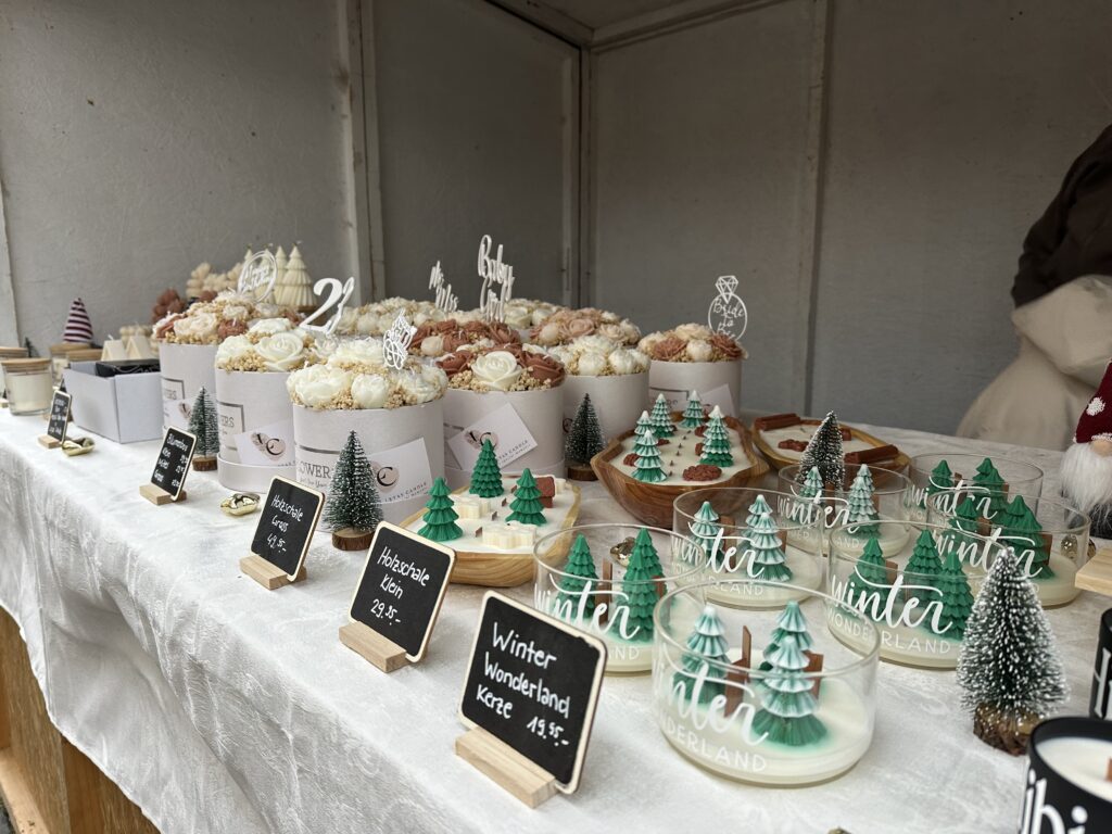 Gläser in denen Winterlandschaften aus Wachs stehen.