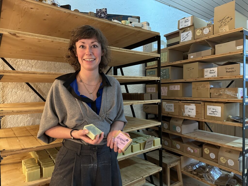 Julia Nigg im Atelier: In der einen Hand hält sie eine Seife, in der anderen deren Verpackung.