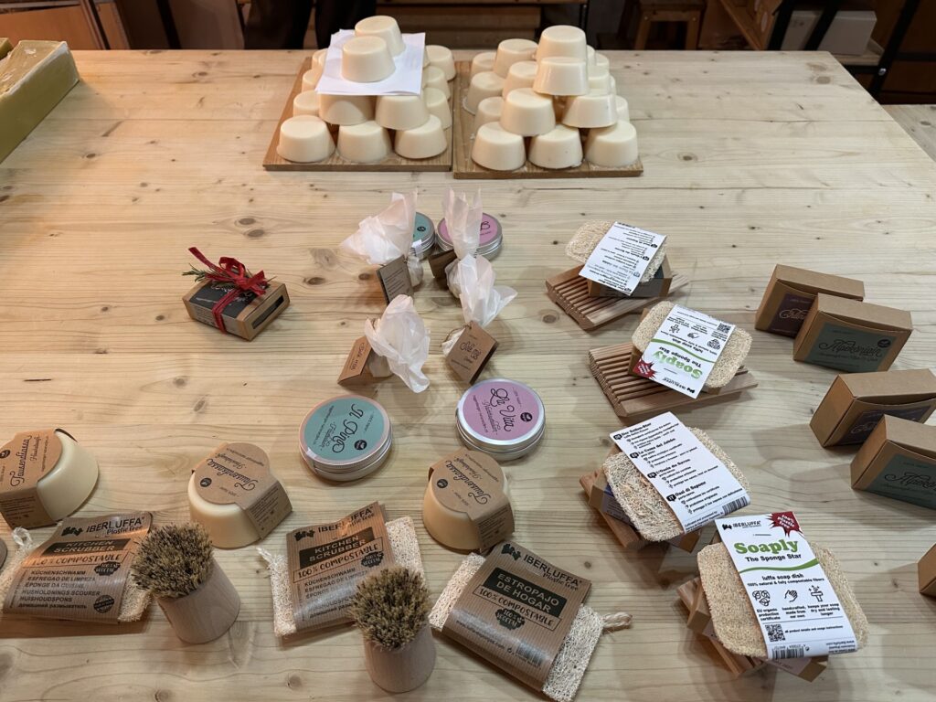 Auf einem Holztisch sind die Produkte von Naturseifen Toggenburg aufgereiht. Einige davon sind als Geschenke verpackt.