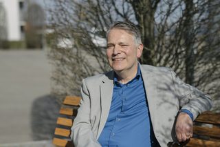Rödiger Voss auf einer Bank vor einem Café im Thurgau.